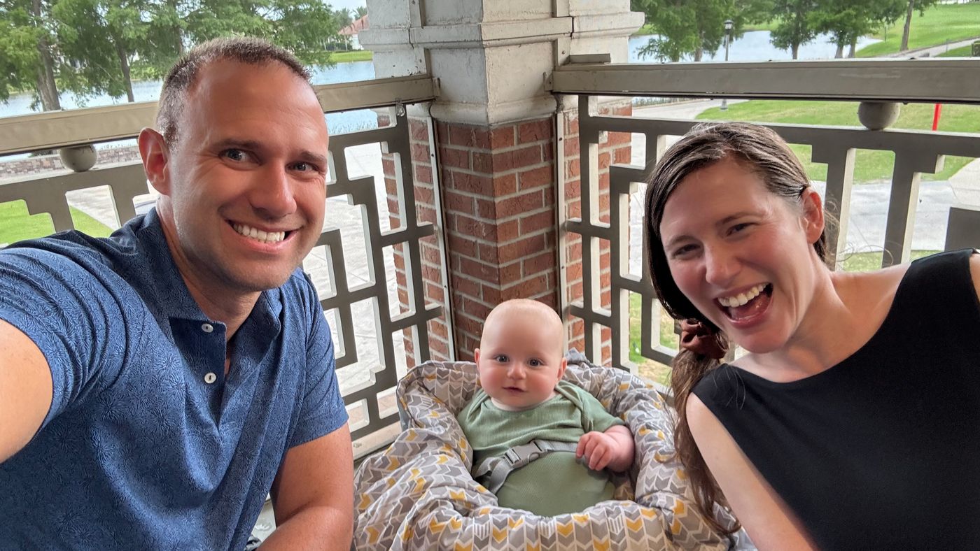 Kenny's family with baby Chase at a restaurant table.